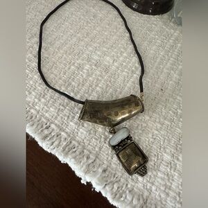 Cultural drop necklace with white stone.